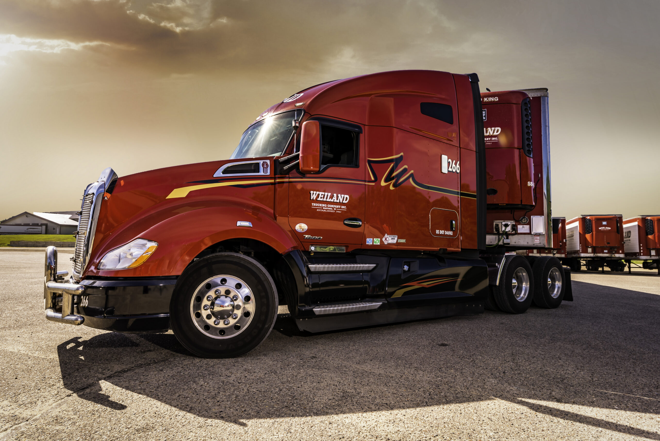 Red Weiland Transportation semi-truck with sleeper cab parked at truck stop